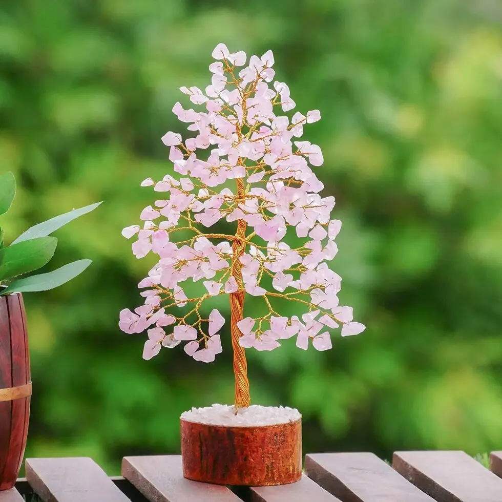 Les Bienfaits du Quartz Rose et la Puissance de l'Arbre de Vie L'Arbre à pierres précieuses avec feuilles de Quartz Rose est un objet de décoration empreint de sens, combinant l'esthétique à la puissance curative des cristaux. Au-delà de sa beauté, il incarne l'Arbre de vie, symbolisant la connexion entre la terre et le ciel, ainsi que la croissance et la régénération.